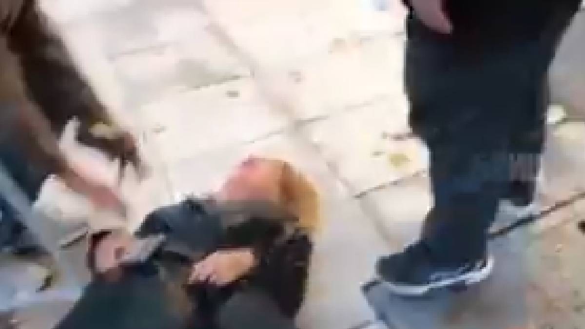 The journalist after being shoved, lying on the sidewalk
